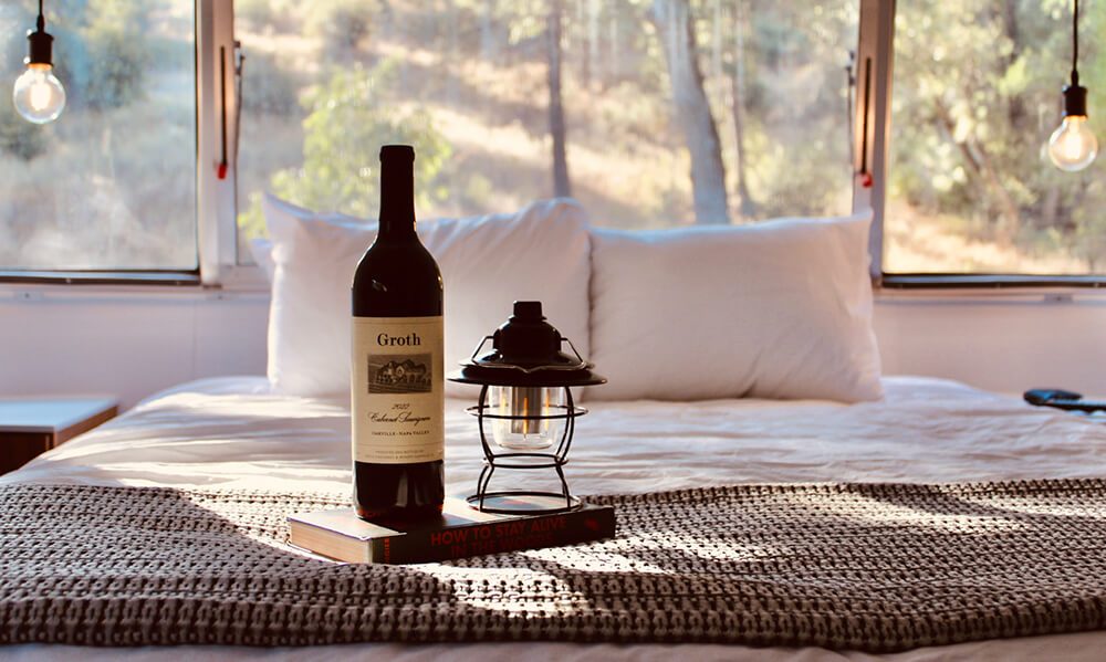 Camp Groth at Yosemite - bottle of Groth Wine and a lantern in a cozy glamping tent.